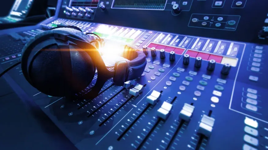 Professional audio mixing console with studio headphones, representing sound editing, music production, and audio recording technology.