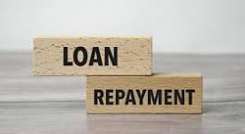 Loan repayment concept with wooden blocks displaying loan and repayment, representing responsible business loan management and debt repayment planning.