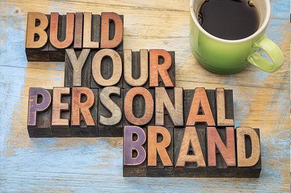 "Build Your Personal Brand" message displayed with wooden letter blocks beside a coffee cup, symbolizing personal branding, digital marketing, and professional business growth.