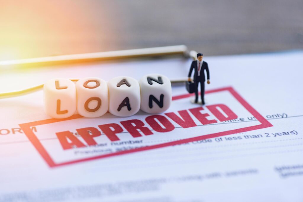 Business loan approval application with loan approval stamp, businessman figure, and financing concept for small business funding.