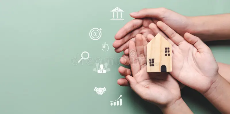 Hands holding a miniature wooden house symbolizing home ownership, property investment, mortgage protection, and real estate financial planning.