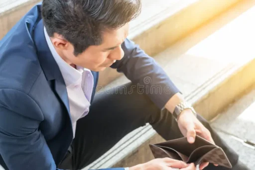 Business owner looking at an empty wallet, illustrating the challenge of starting a business with no money in 2026.