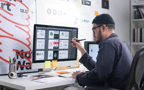 Graphic designer creating digital designs on a desktop computer, representing a creative freelance business started with little or no money.
