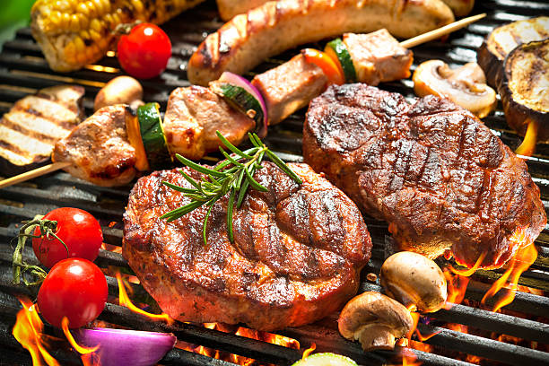 BBQ business featuring grilled steaks, sausages, vegetables, and mushrooms cooking over an open barbecue flame.