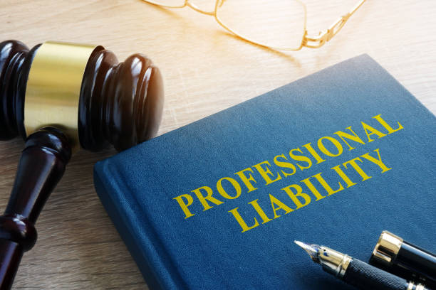 Professional liability insurance concept featuring a legal gavel, policy book labeled “Professional Liability,” eyeglasses, and a fountain pen. 