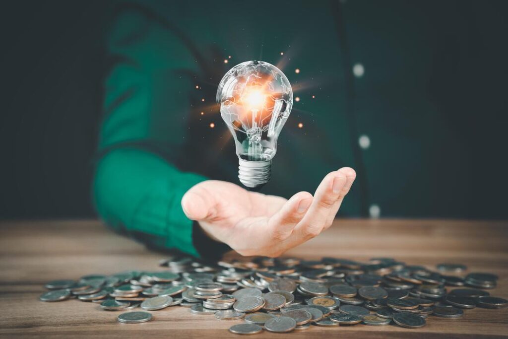 Business idea represented by a glowing light bulb over money, symbolizing creative entrepreneurship, innovation, and profitable opportunities. 