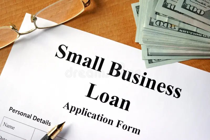 Small business loan application form with cash and documents illustrating how to get a startup business loan with no money.