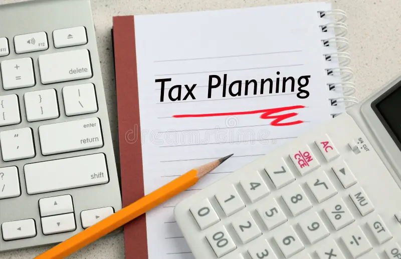Tax planning checklist displayed on a notebook beside a calculator, keyboard, and pencil on a desk.