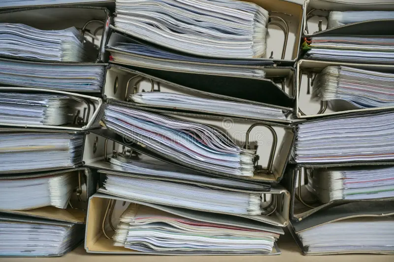 Stacks of ring binders filled with documents, representing record keeping and documentation.